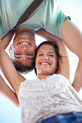 Buy stock photo Cropped view of a young couple smiling while looking down at the camera