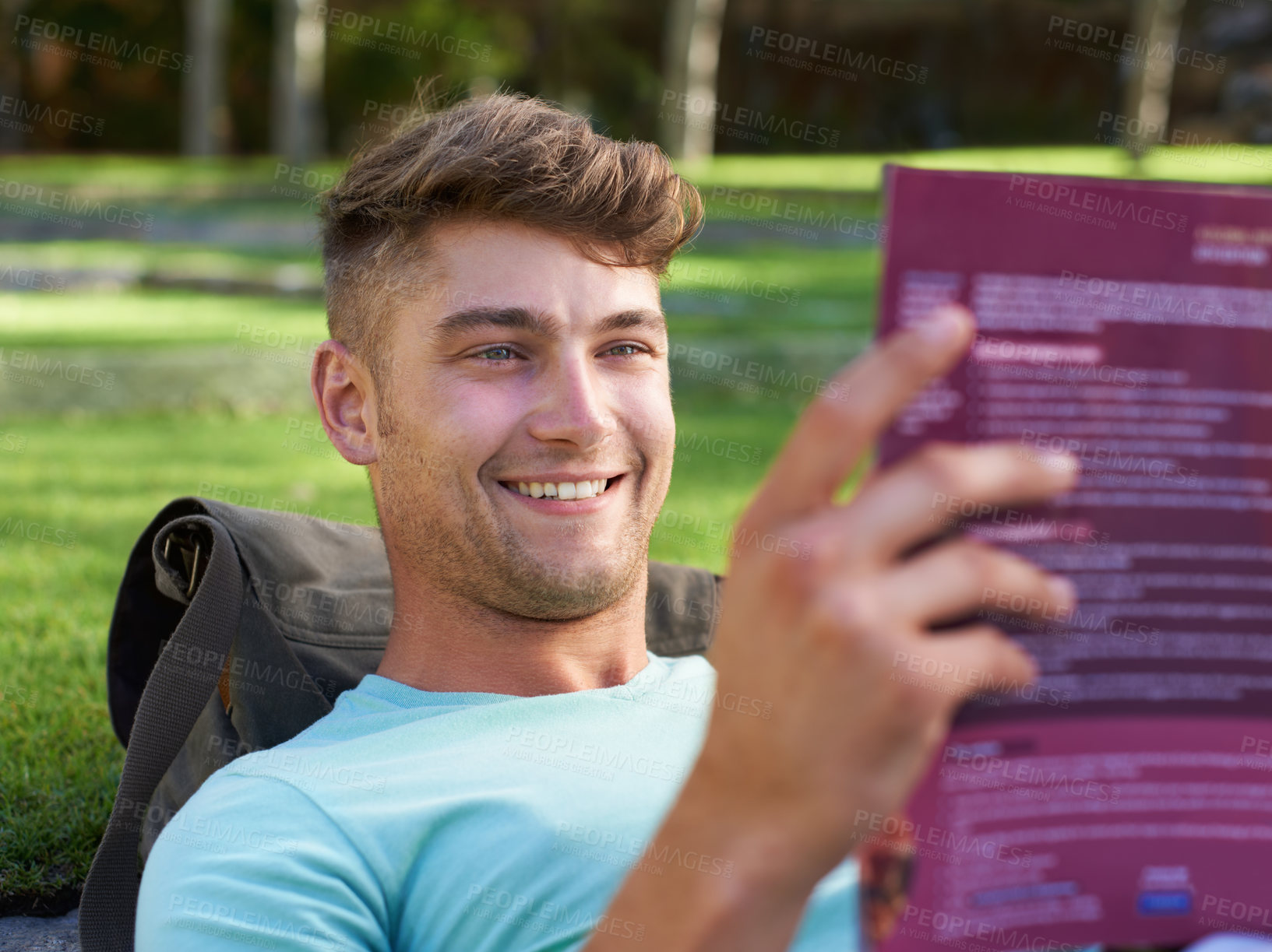 Buy stock photo Man, student and book on lawn for reading, smile and ideas with learning for development at campus. Person, studying and happy with scholarship, information and knowledge for education at college