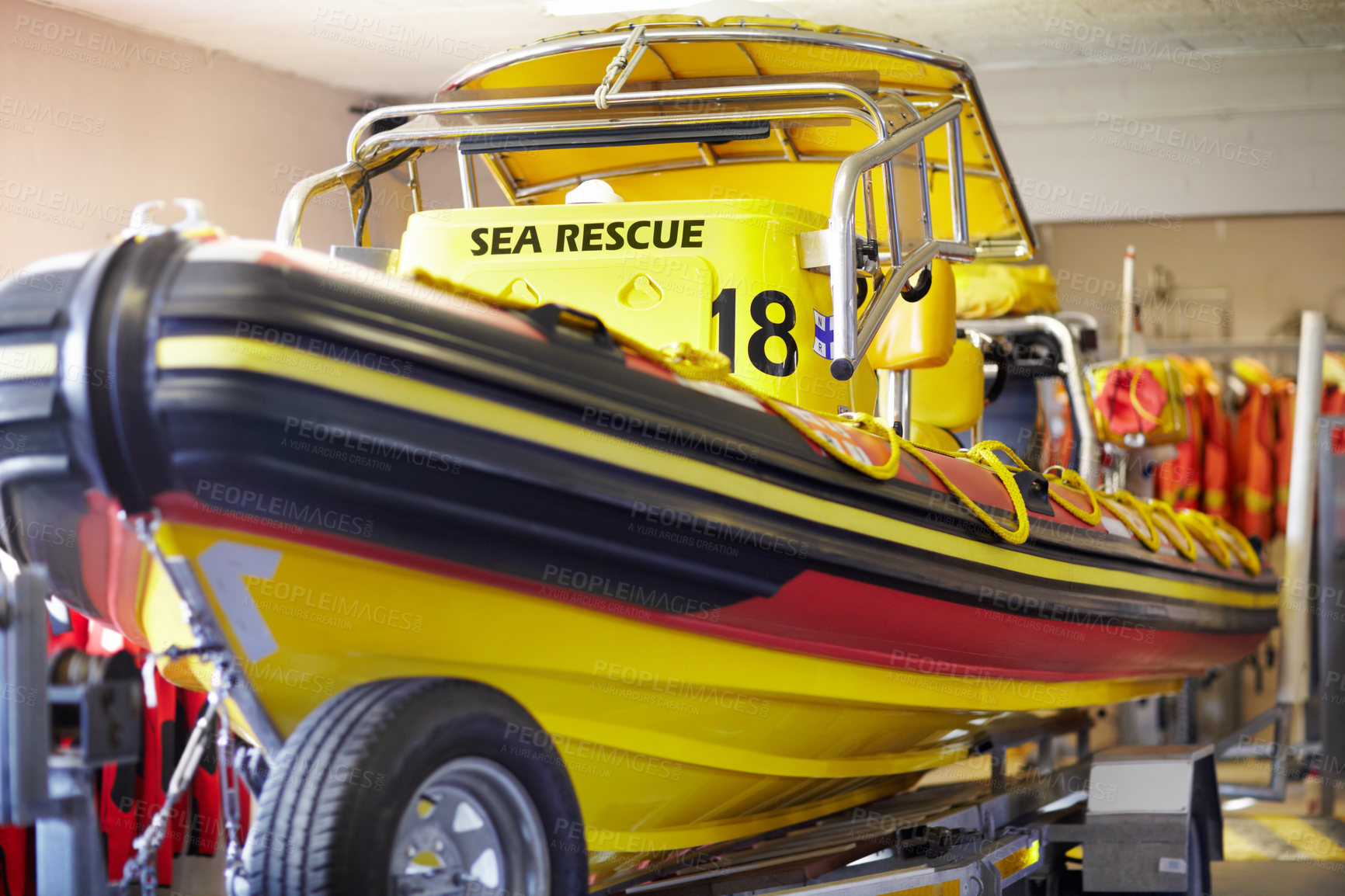 Buy stock photo Closeup of a sea rescue boat inside a lifeguard station. A yellow stationery coast guard emergency vessel on a trailer in a garage ready to be used for ocean patrolling security and transportation