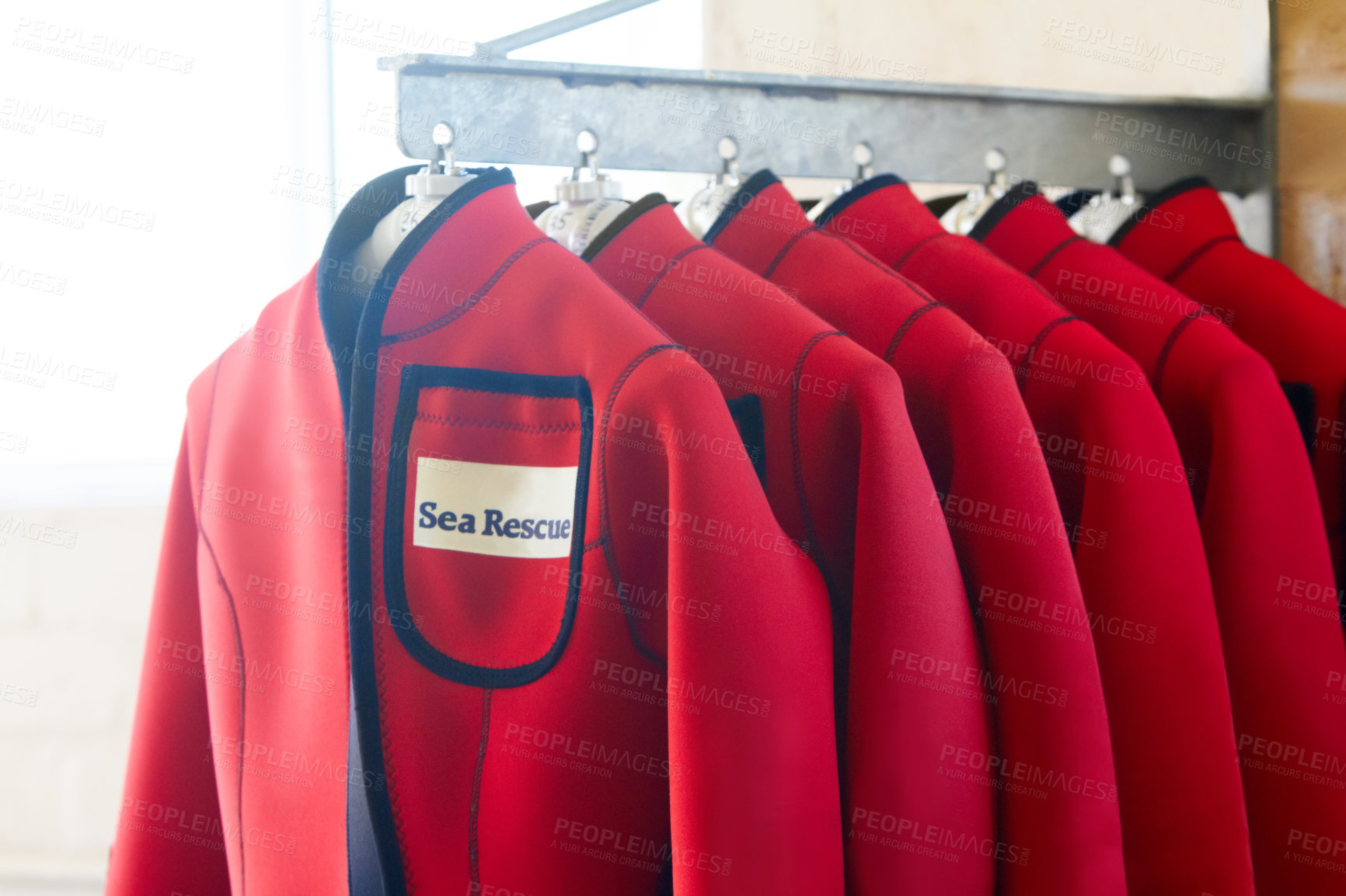 Buy stock photo Shot of wetsuits on a hanger