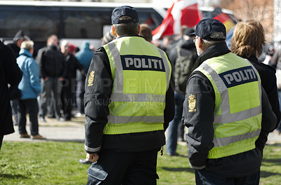 Buy stock photo Law enforcement, safety and crowd control with police officer in city for peace, security or authority. Emergency services, justice and guard with person in Denmark street for rally, order and arrest