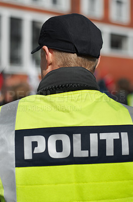 Buy stock photo Law enforcement, protection and security with back of police officer in city for peace, safety or rally. Emergency services, justice and guard with person in Denmark street for help, order and arrest
