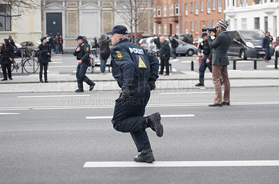 Buy stock photo Police officer, man and running in street with crowd safety with protection service for public in city. People, law enforcement and justice in danger, arrest or warning on urban road in Copenhagen