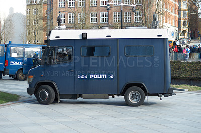 Buy stock photo Police, van and city for transport, safety or protection service for public justice in in street. Vehicle, law enforcement and outdoor for danger, arrest and armored truck on urban road in Copenhagen
