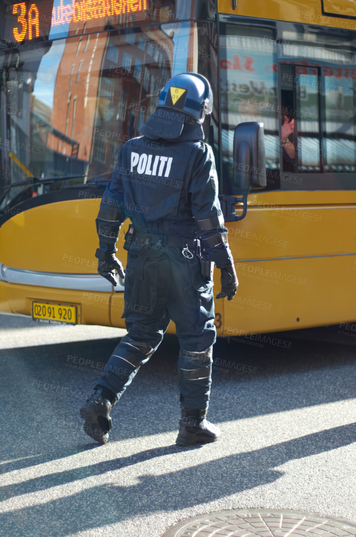 Buy stock photo Rearview shot of a police man in riot gear