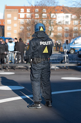 Buy stock photo Safety, riot and rally with police officer in city for law enforcement, protection or security. Brave, uniform and government with person in street for protest demonstration, human rights or activist