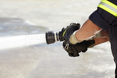 Buy stock photo Hands, spray and nozzle for water, firefighter and help in emergency, brave or stop inferno in uniform. Fireman, fire hose and fearless on mission to rescue, health and safety service at job outdoor