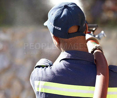 Buy stock photo Back, fireman and spray hose with water for emergency with helping, uniform and brave to stop inferno. Firefighter, fire and fearless on mission for rescue, health and safety service at job outdoor