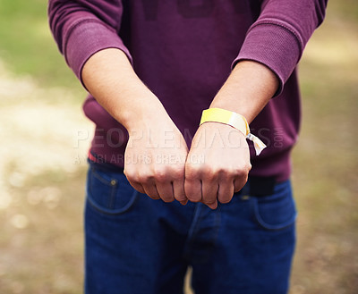 Buy stock photo Closeup, hands and outdoor with person, music festival and bracelet for an event and partying. Vacation, outside and fist with band and weekend break with summer and holiday with sunshine and ribbon
