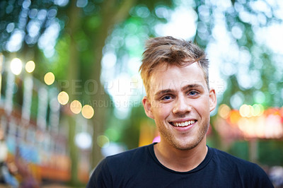 Buy stock photo A handsome young man smiling at the camera while standing outside