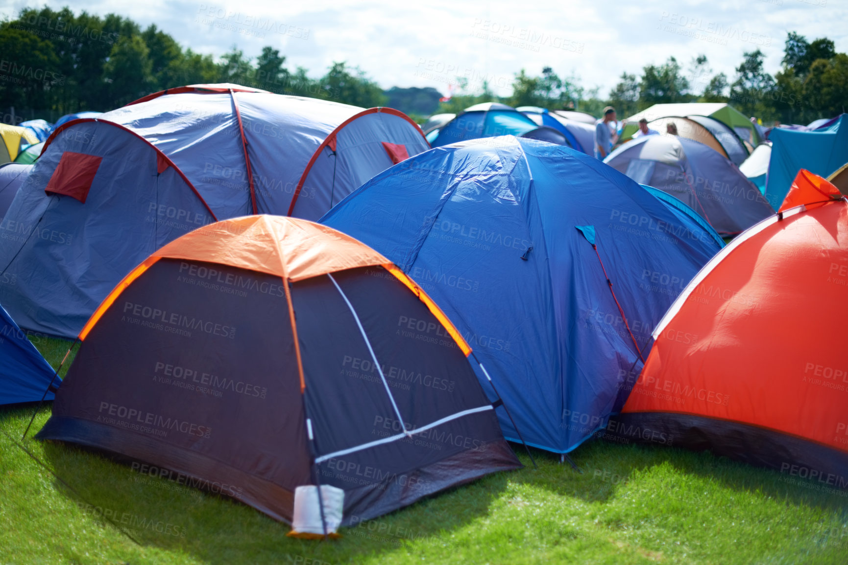 Buy stock photo Group, colourful and camping tents in nature outside of a music festival campsite. Row of canopies placed on ground at musical concert, entertainment event and carnival celebration outdoor on grass
