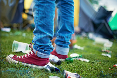 Buy stock photo Feet, event and a person with litter on grass and plastic bottles, cans at an outdoor festival. People at a party,  concert with garbage on a field and shoes with pollution for recycling trash