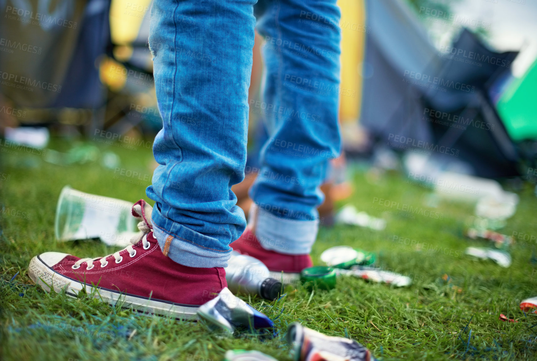 Buy stock photo Feet, event and a person with litter on grass and plastic bottles, cans at an outdoor festival. People at a party,  concert with garbage on a field and shoes with pollution for recycling trash