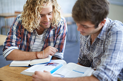 Buy stock photo Shot of two male students studying together in class