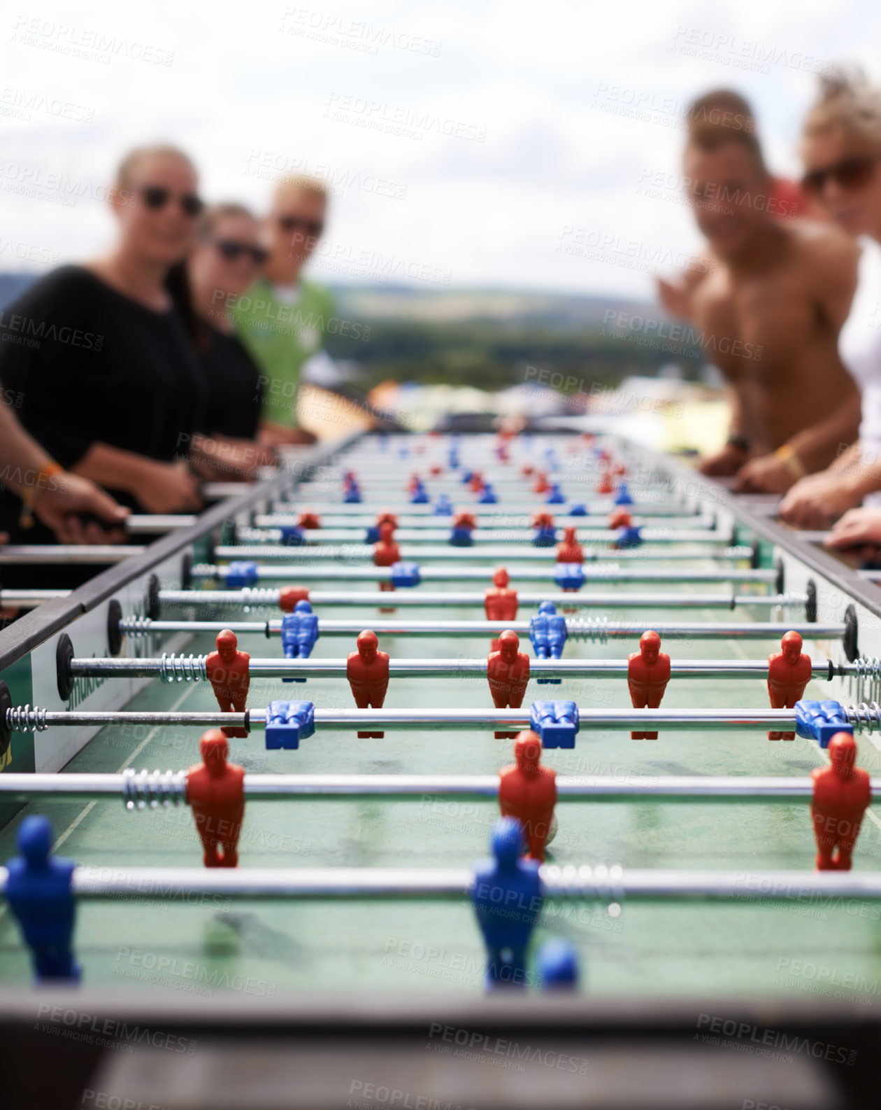 Buy stock photo Friends playing with a foosball at a party for competition, fun skill or sports event. Celebration, activity and group of people enjoying a football table game or match for a friendly championship.