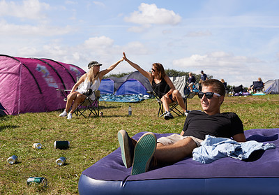 Buy stock photo Man, relax and mattress at outdoor festival with happiness, camping and sunshine on grass. Guy, happy and women friends with high five, smile and support for summer, camp and party, event or carnival