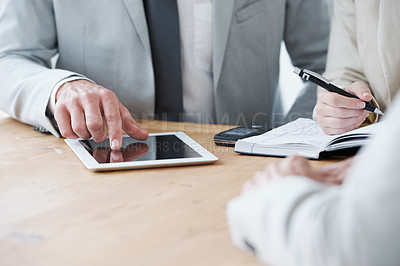 Buy stock photo Cropped shot of a businessman using a digital tablet during a meeting