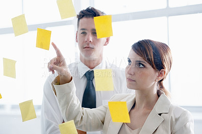 Buy stock photo Teamwork, brainstorming and meeting in office with sticky notes for planning, ideas and schedule. Colleagues, thinking and pointing at paper for collaboration, vision and strategy on glass wall