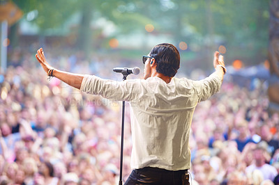 Buy stock photo A singer performing on stage at an outdoor music festival