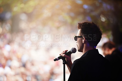 Buy stock photo Singer, music festival and man with performance, party and outdoor for event and crowd with celebration. Person, guy and artist with a mic and audience with sunshine and blur background with creative