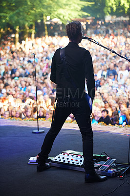 Buy stock photo Singer, music festival and man with performance, back and outdoor for event and crowd with celebration. Person, party and artist with microphone and audience with sunshine and fans screaming with fun