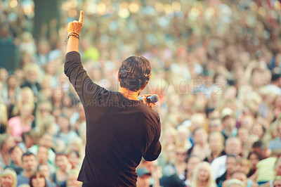 Buy stock photo A singer performing in front of a massive crowd at a concert