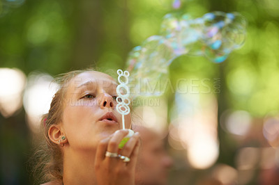 Buy stock photo Woman, play and bubbles outdoors in blurred background, face and creative with freedom, happiness. Summer, game and gen z having fun in nature with peace in park and sunshine and water with soap