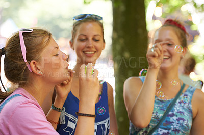 Buy stock photo Park, friends and women with bubbles in nature on holiday, vacation and weekend outdoors. Happy, smile and people blowing soap bubble for bonding, fun and relax together on adventure, travel and trip