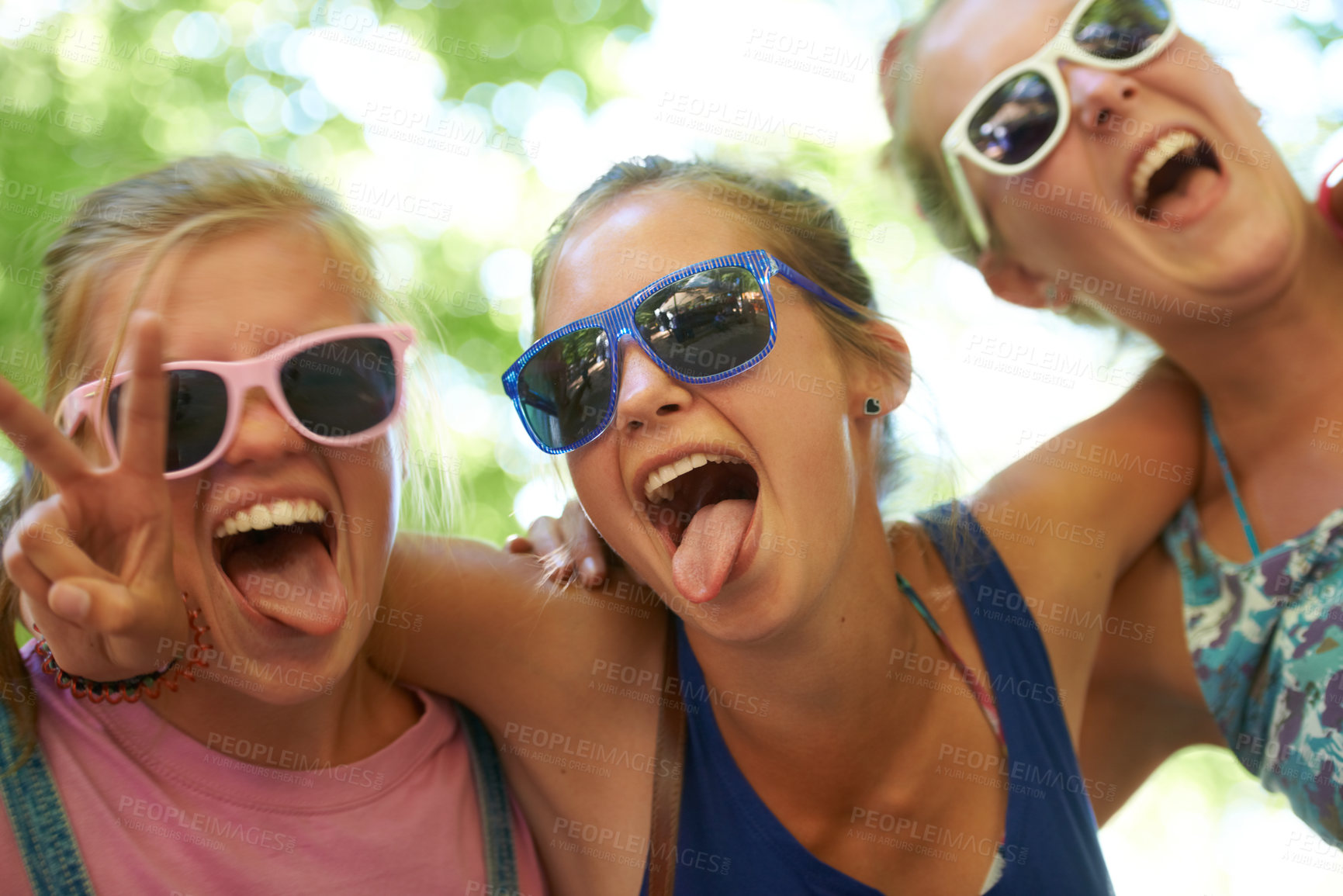 Buy stock photo Portrait, music festival and women with sunglasses, funny and silly with happiness and bonding together. Funky eyewear, goofy or outdoor with friends or peace sign with embrace, excited or summer fun