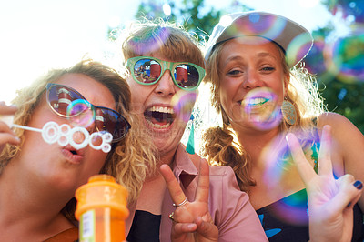 Buy stock photo Women, friends and bubbles for blowing or happy outdoor with sunglasses or peace sign for holiday and relax. People, face and plastic wand or toy for playing and laughing with vacation or adventure
