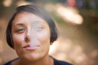 Buy stock photo Portrait, woman and blowing smoke with mouth for addiction, mental health and nicotine in forest. Stress relief, female person and smoker for unhealthy, cannabis and habit to relax in Portugal