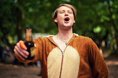 Buy stock photo Man, outdoor and cheers with beer to drink, toast and happy celebration in bear outfit. Animal, suit and person smile in forest with lager, bottle and drunk from drinking alcohol in park or woods