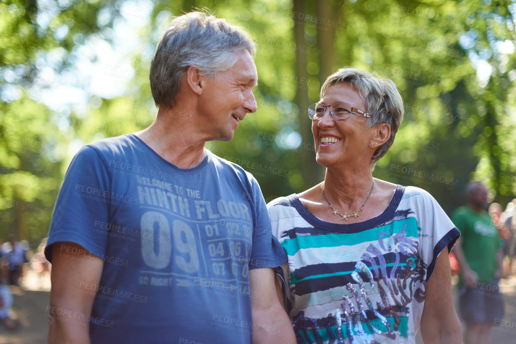 Buy stock photo Mature, couple and walking in forest with happy adventure or travel on holiday in summer for vacation. People, smile and relax outdoor in park, woods or together in nature at event or festival