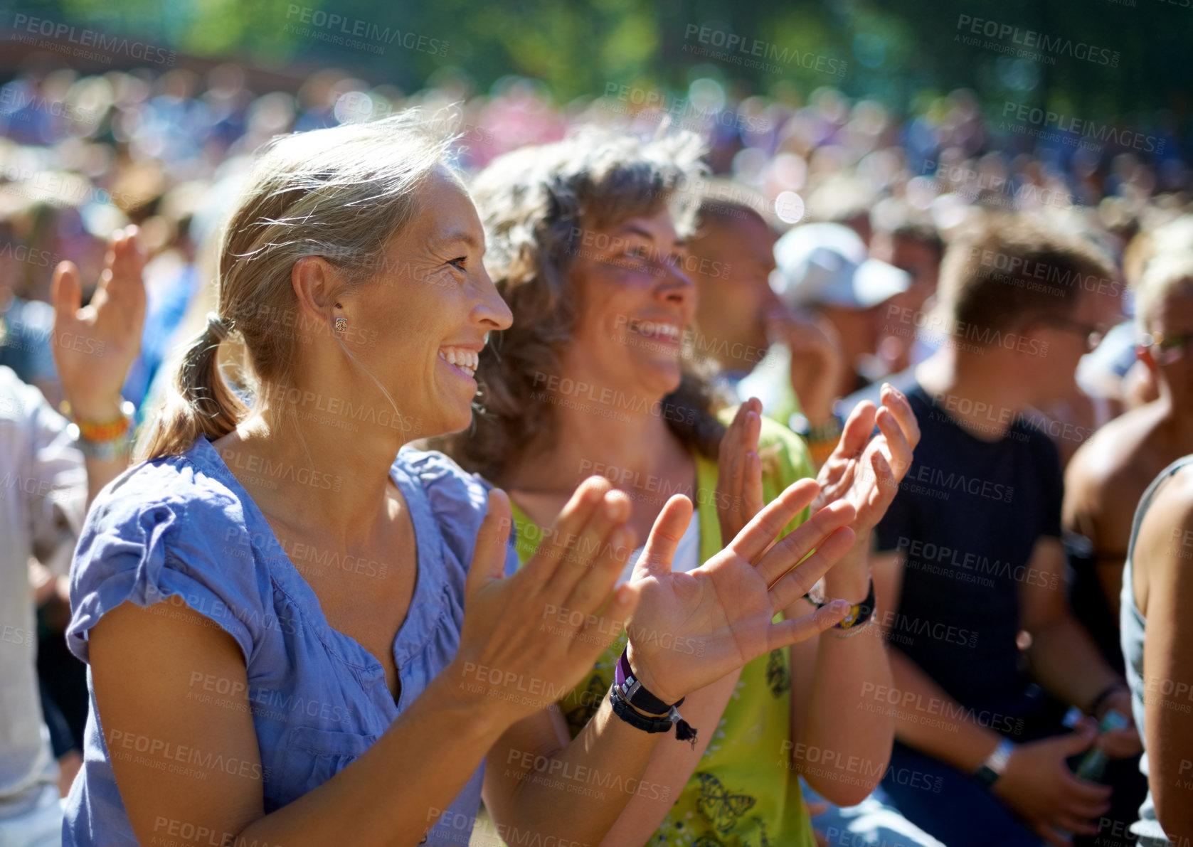 Buy stock photo Two mature woman sitting outdoors at a music festival