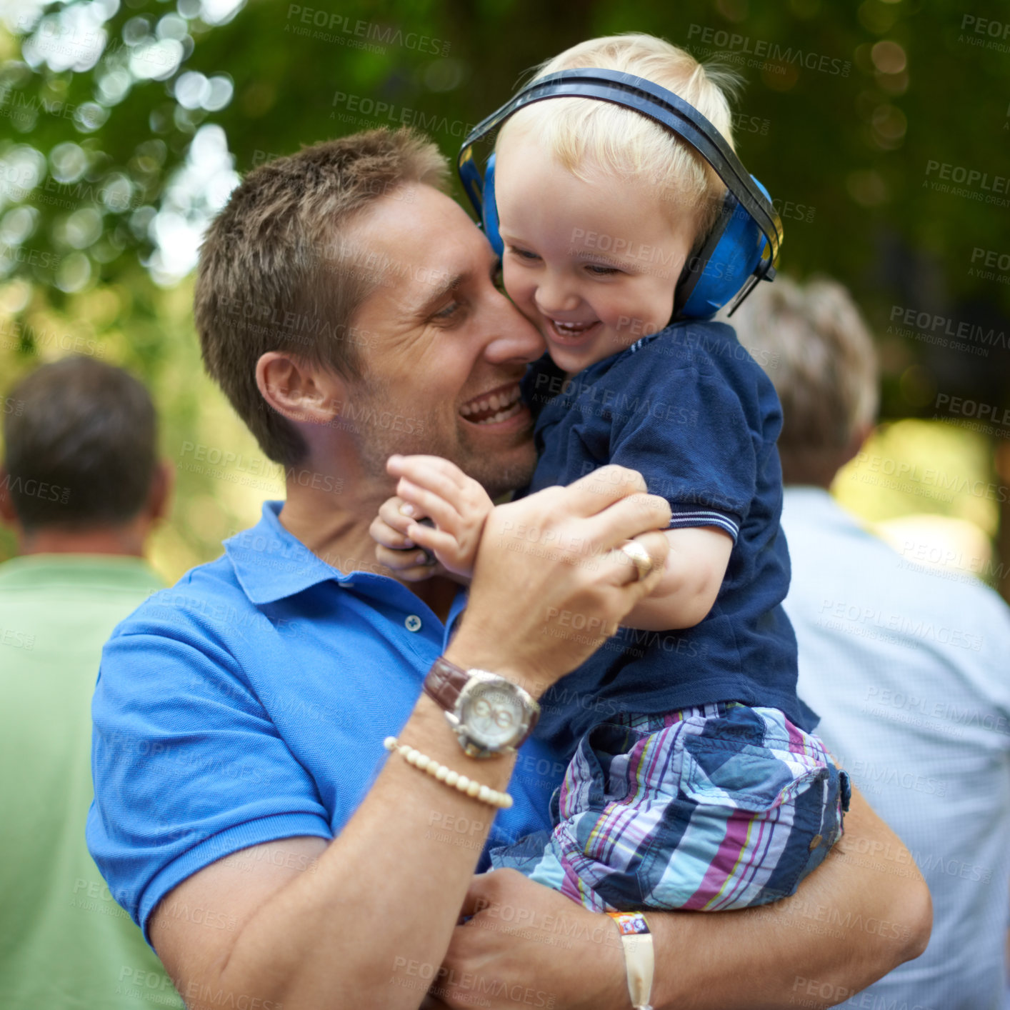 Buy stock photo Father, hug and baby at outdoor festival for family together, happiness and headphones for loud sound. Man, kid and love for child, playful and laugh at music concert in Hollywood for summer holiday