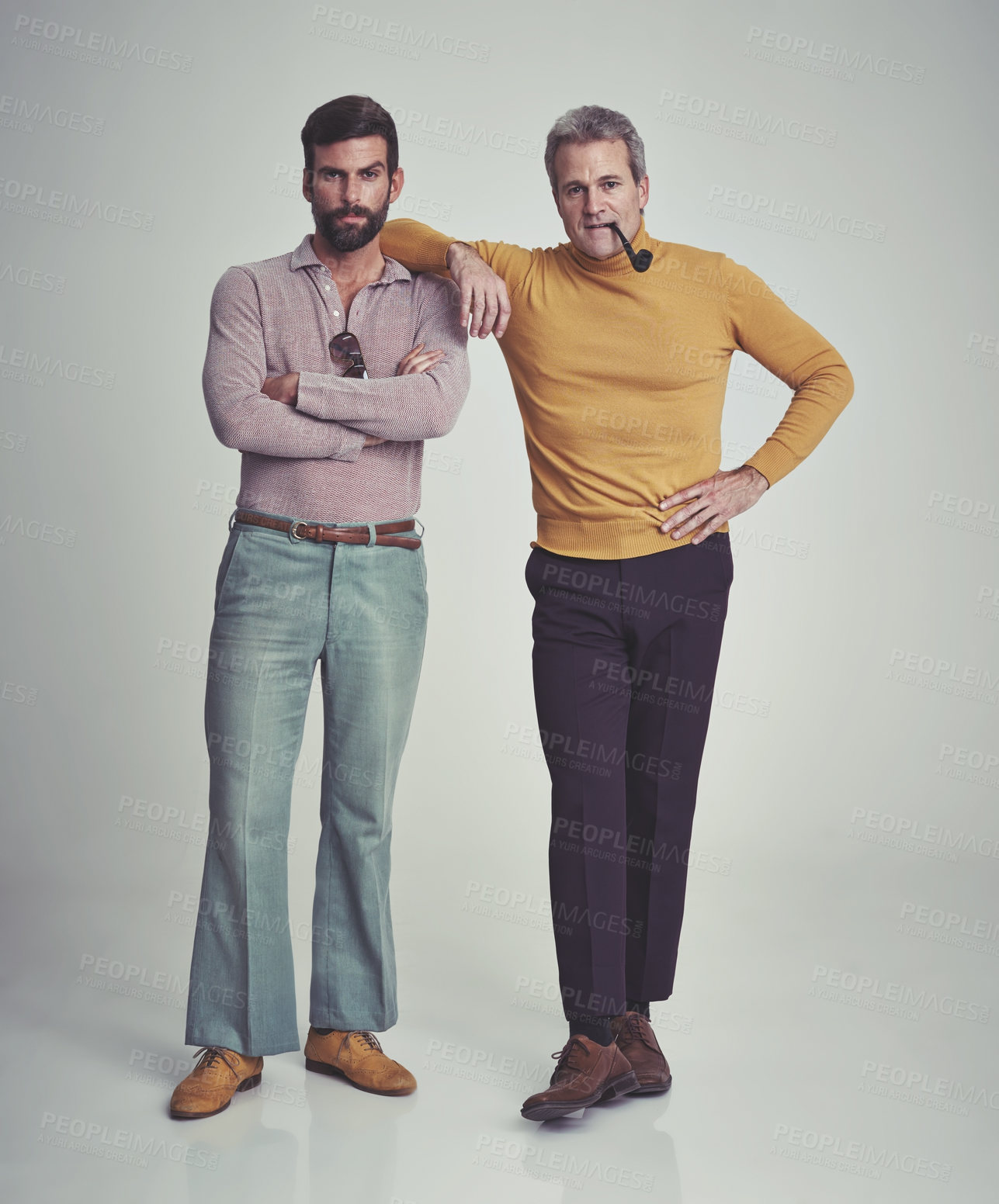 Buy stock photo Studio shot of two men standing together while wearing retro 70s wear