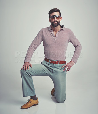 Buy stock photo Vintage, fashion and portrait of man with 70s retro aesthetic in gray background of studio. Smoking, pipe and person with confidence and pride in funky sunglasses, clothes and unique style from past