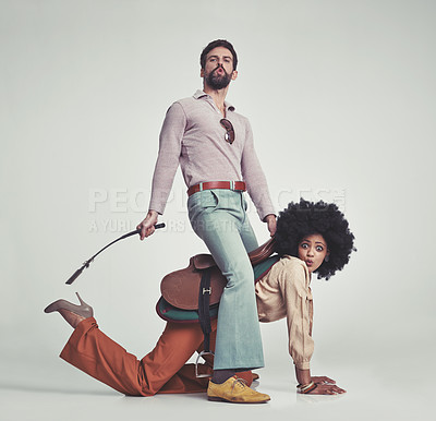 Buy stock photo Vintage, man and woman or riding crop in studio with piggyback, portrait and funny face for retro style. Friends, people and 70s outfit with hipster clothes or comic expression with white background