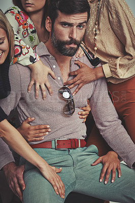 Buy stock photo Studio shot of an attractive man in retro 70s wear surrounded and being touched by women