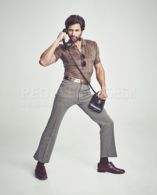 Buy stock photo A handsome man on a retro telephone while striking a pose