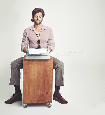 Buy stock photo A young man in 70s style clothing using a typewriter