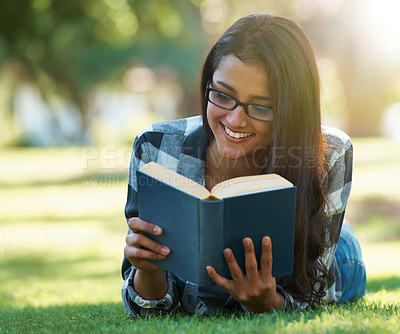 Buy stock photo Happy woman, student and reading book on green grass for literature, studying or story in nature. Female person, smart or young adult with smile or glasses for chapter, learning or education at park