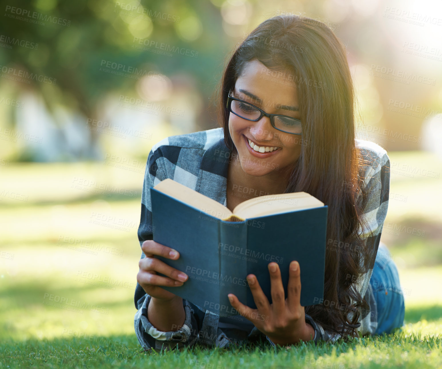 Buy stock photo Happy woman, student and reading book on green grass for literature, studying or story in nature. Female person, smart or young adult with smile or glasses for chapter, learning or education at park