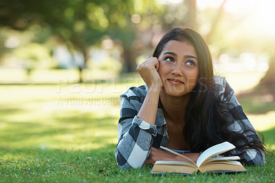 Buy stock photo Happy woman, student and thinking with book for reading, literature or studying on green grass. Young or thoughtful female person with smile in wonder for chapter, learning or outdoor story in nature