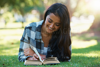 Buy stock photo Woman, information and reading book on grass, literature and smiling for fiction or fantasy story. Female person, nature and relaxing on lawn for knowledge, novel and student studying in garden