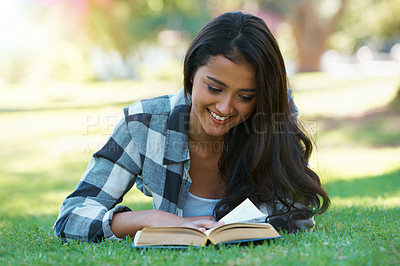 Buy stock photo Woman, novel and reading book on grass, literature and smiling for fiction or fantasy story. Happy female person, nature and relaxing on lawn for knowledge, education and student studying in garden