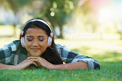 Buy stock photo Music headphones, park or woman on grass to relax for rest in garden, nature or field with smile or peace. Eyes closed, streaming or calm person on break with playlist for radio, podcast or wellness