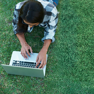 Buy stock photo Above, grass and person typing on laptop in park with college research, project or learning on campus. University, student and girl reading online with ebook, education and study on lawn in garden