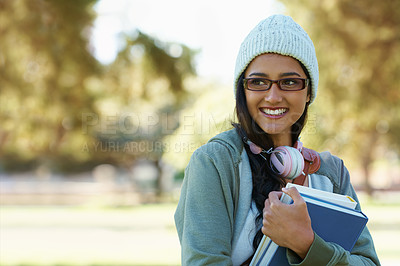 Buy stock photo Thinking, student and happy woman in park with books for studying,  learning and reading outdoors. Education, college and person with smile, textbooks and headphones relax in nature for university