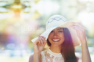 Buy stock photo A happy young woman standing in the park wearing a sunhat